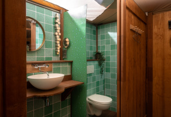 Salle de bain dans la Dream suite du safari-tente au Holiday Park Mölke, Pays-Bas, carrelée verte et bois.