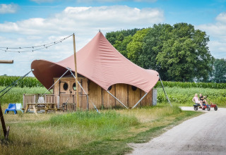 Safari-Zelt Dream Suite im Holiday Park Mölke, Niederlande, mit Kindern auf einem Pedal-Go-Kart.