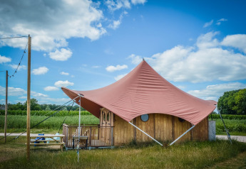 Tenda safari Dream suite al Holiday Park Mölke, Paesi Bassi, con tetto rosa e pareti in legno.