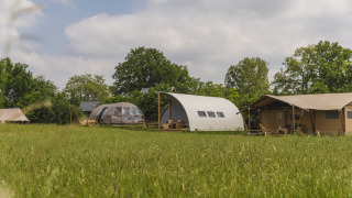 Modernas cabañas de camping en Holiday Park Mölke, Países Bajos, con Riverdome y zona sanitaria en un campo.