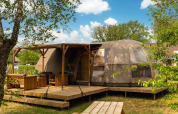 Outdoor view of Riverdome lodge with covered terrace at Holiday Park Mölke in the Netherlands
