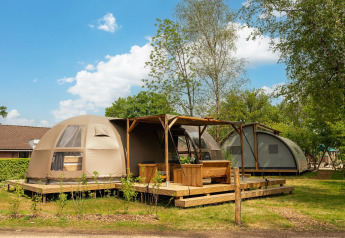 Vista esterna della lodge Riverdome con terrazza in legno al Holiday Park Mölke nei Paesi Bassi.