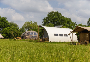 Riverdome et installations sanitaires au Holiday Park Mölke aux Pays-Bas, entourés d’herbe verte luxuriante.