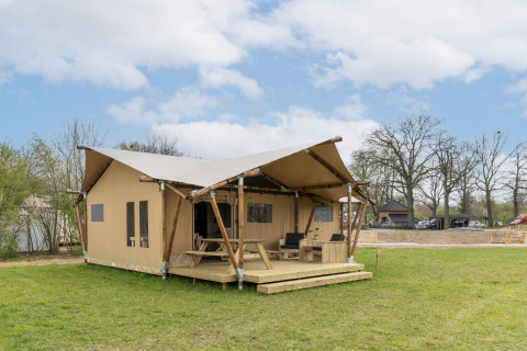 Tienda safari con aseo privado en Holiday Park Mölke, Países Bajos, ubicada en un campo verde y abierto.