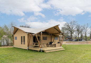 Safaritent met eigen sanitair op Holiday Park Mölke in Nederland, gelegen op een open grasveld.