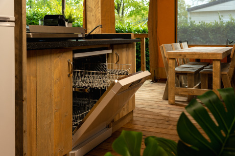 Cocina en tienda safari con lavavajillas y mesa de comedor en Holiday Park Mölke, Países Bajos.