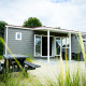 Udsigt til Dune Lodge ved Holiday Park Duinhoeve i Holland med udendørs siddepladser og picnicbord.