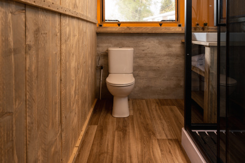 Bagno con pareti in legno e WC nella tenda Safari 'the bartender' al Holiday Park Mölke, Paesi Bassi.