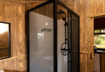 Moderne douchecabine in Safari tent 'the bartender' met houten wanden bij Holiday Park Mölke in Nederland.