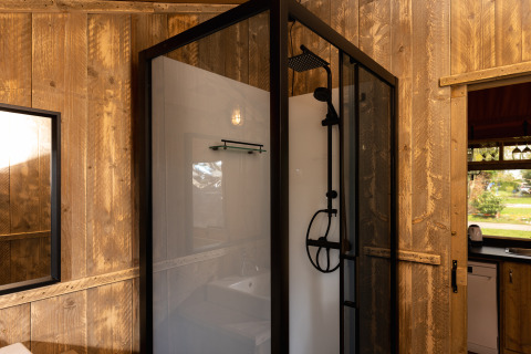 Moderne douche in het Safari tent 'the bartender' met houten wanden aan Holiday Park Mölke, Nederland.