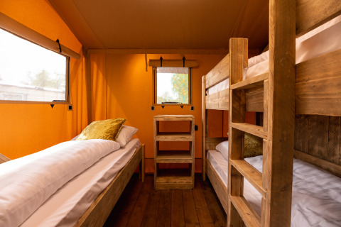 Interieur van safaritent 'the bartender' met solo bed en stapelbed bij Holiday Park Mölke, Nederland.