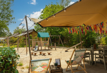 Spielplatz und Outdoor-Sitzbereich am Safari-Zelt ‘the bartender’ im Holiday Park Mölke, Niederlande.