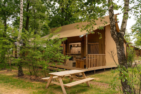 Tenda safari 'The Bartender' con terrazza e tavolo da picnic a Holiday Park Mölke, Paesi Bassi.