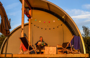 En person slapper af på Panorama Lodge ved Holiday Park Mölke, Nederlandene, omgivet af liggestole.