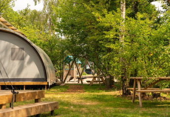 Panorama Lodge mit Bad in Holiday Park Mölke, Niederlande, umgeben von Bäumen und Picknicktischen.