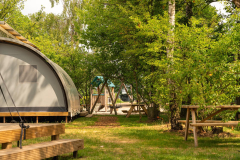 Panorama Lodge with bathroom surrounded by greenery and picnic tables at Holiday Park Mölke, Netherlands.