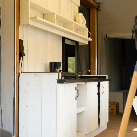 Moderne minikøkken med hvide træskabe og sorte detaljer i Panorama Lodge på Holiday Park Mölke, Holland.