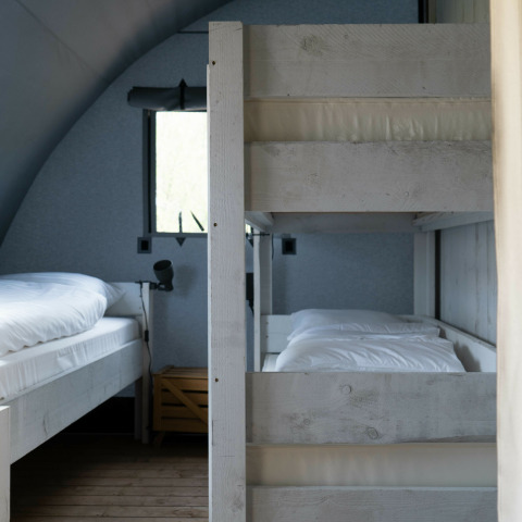 Et foto af soveområdet i Panorama Lodge på Holiday Park Mölke, med køjesenge og enkeltseng.