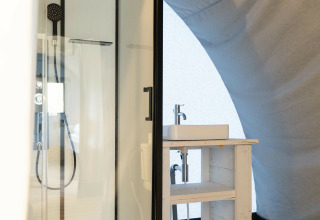 Moderne badkamer in Panorama Lodge bij Holiday Park Mölke, Nederland, met douchecabine en wastafel.
