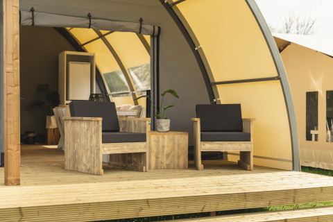 Træmøbleret veranda ved Panorama Lodge med badeværelse i Holiday Park Mölke, Holland, solrig dag.