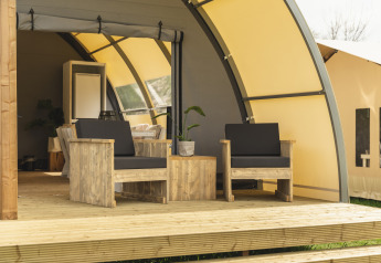 Terraza amueblada de madera en Panorama Lodge con baño en Holiday Park Mölke, Países Bajos, soleado.