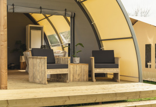 Veranda in legno con poltrone presso Panorama Lodge con bagno, Holiday Park Mölke, Paesi Bassi, soleggiato.