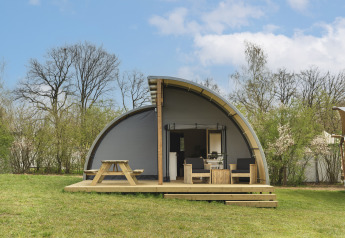 Vooraanzicht van Panorama Lodge + badkamer in Holiday Park Mölke, Nederland, met houten terras en tuinmeubilair.
