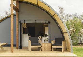 Buiten terras met twee houten stoelen bij Panorama Lodge + badkamer, Holiday Park Mölke, Nederland.