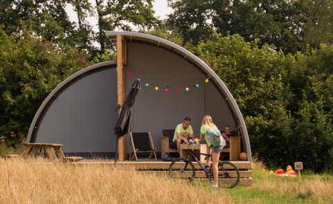 Familie entspannt vor der Panorama Lodge mit Bad im Ferienpark Mölke, Niederlande, Sommertag