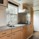 Modern kitchen in the Bungalow at the Regge with stove, coffee maker and window at Holiday Park Mölke, Netherlands.