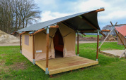 Safari-Zelt mit Holzrahmen und Veranda im Holiday Park Mölke, Niederlande, auf grünem Rasen.