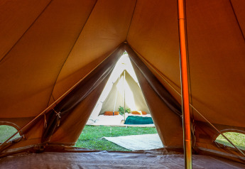 Uitzicht van binnenuit een tipi tent aan Holiday Park Mölke in Nederland, met sfeervol glamping-interieur.
