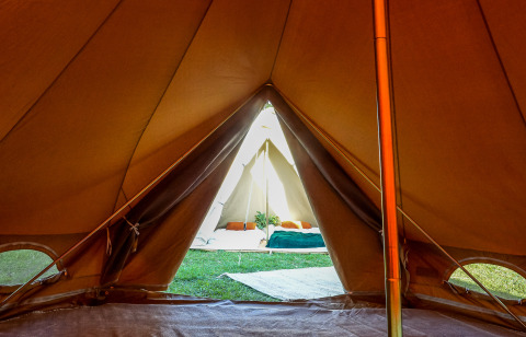 Udsigt fra inde i en tipi-telt ved Holiday Park Mölke i Holland, med glamping-indretning og seng.