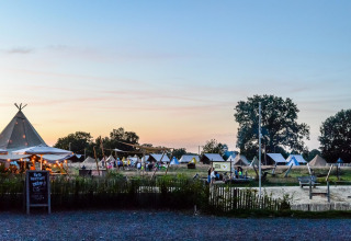 Pop-up glamping på Holiday Park Mölke i Holland med safari telte og chill område under solnedgangen.