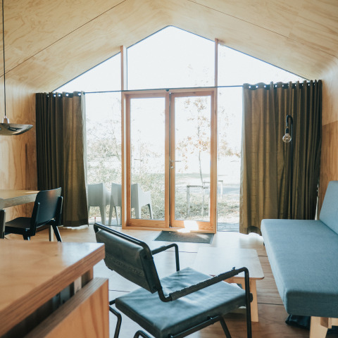 Interiør af et Wikkel tiny house på Holiday park De Klepperstee i Holland med moderne træmøbler.