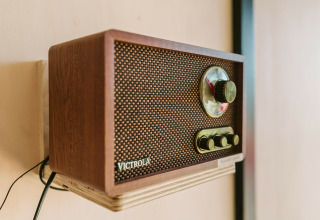 Retro Victrola-radio op een houten plank, gefotografeerd in tiny house Hoagte op De Klepperstee, Nederland.