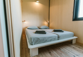 Slaapkamer in The Hoagte tiny house op vakantiepark De Klepperstee in Nederland met twee eenpersoonsbedden.