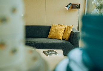 Moderne bank met gele kussens en salontafel in een lodge bij vakantiepark De Klepperstee, Nederland.