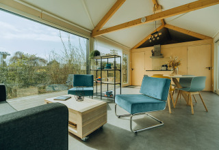 Moderne lodge på Holiday park De Klepperstee, Holland, med store vinduer og stilfuld, lys indretning.
