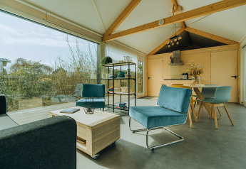 Interno moderno di una lodge al Holiday park De Klepperstee nei Paesi Bassi con ampie finestre e arredo elegante.