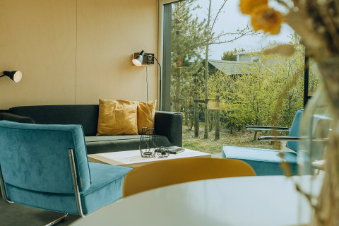 Modernes Wohnzimmer in der t Kroaje Lodge im Ferienpark De Klepperstee, Niederlande, mit großen Fenstern.