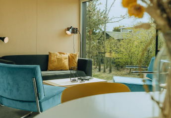 Moderne woonkamer in t Kroaje lodge bij vakantiepark De Klepperstee, Nederland, met grote ramen.