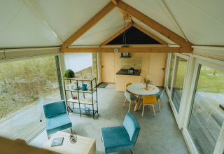 Modern lodge-interieur bij t Kroaje, Holiday park De Klepperstee, Nederland, met grote ramen en stijlvolle meubels.