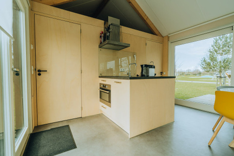 Moderne Lodge-Küche bei t Kroaje im Ferienpark De Klepperstee, Niederlande, mit großen Fenstern und Blick.