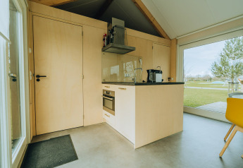 Moderne Lodge-Küche bei t Kroaje im Ferienpark De Klepperstee, Niederlande, mit großen Fenstern und Blick.