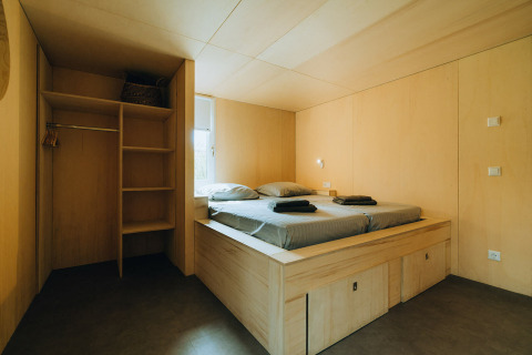 Dormitorio moderno con cama y armario de madera en 't Kroaje, parque Holiday De Klepperstee, Países Bajos.