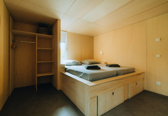 Moderne slaapkamer met houten bed en kast bij 't Kroaje, Holiday park De Klepperstee, Nederland.