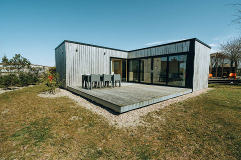 Cabane moderne en bois au Huus van Hanse, De Klepperstee, Pays-Bas, avec terrasse spacieuse et mobilier.