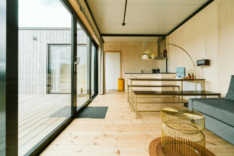 Moderne stue og køkken i Huus van Hanse på Holiday park De Klepperstee med store vinduer og trægulv.
