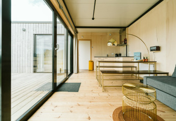 Moderne woonkamer en keuken in Huus van Hanse, De Klepperstee, Nederland, met grote glazen schuifdeuren.